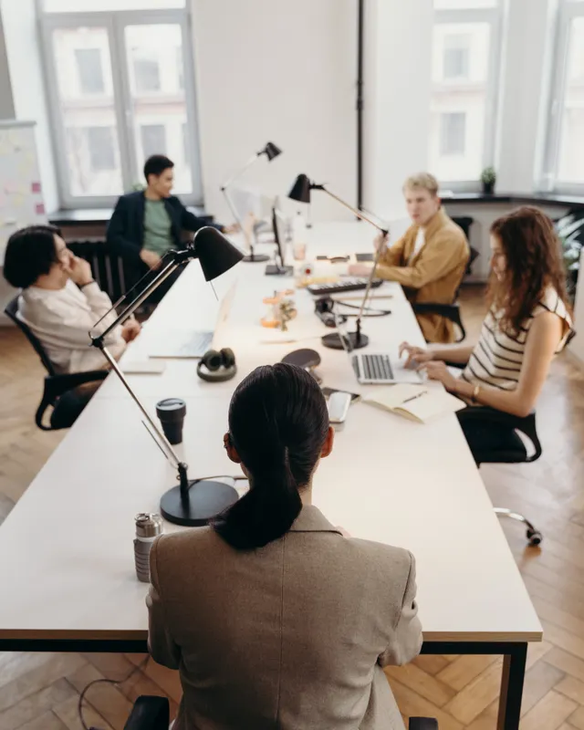 A team working at a long shared desk in a bright open-plan office
