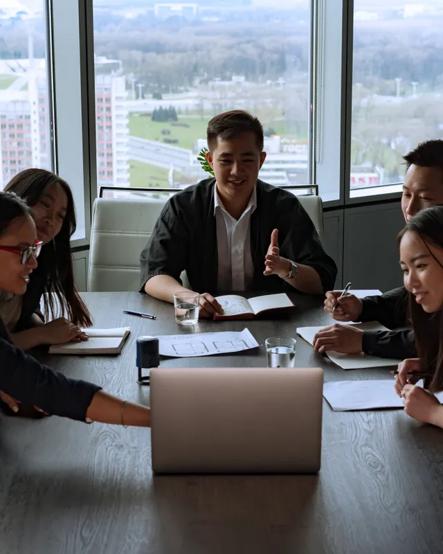 A team meeting around a table in an office overlooking the city